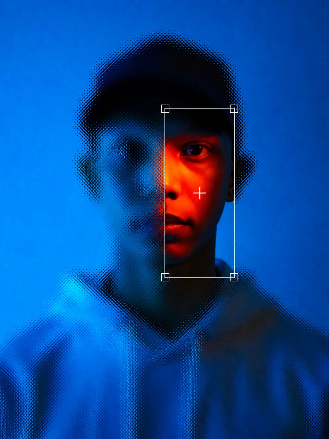 A portrait lit half in red, half dissolving into blue, with a camera reticle framing the side still in focus.